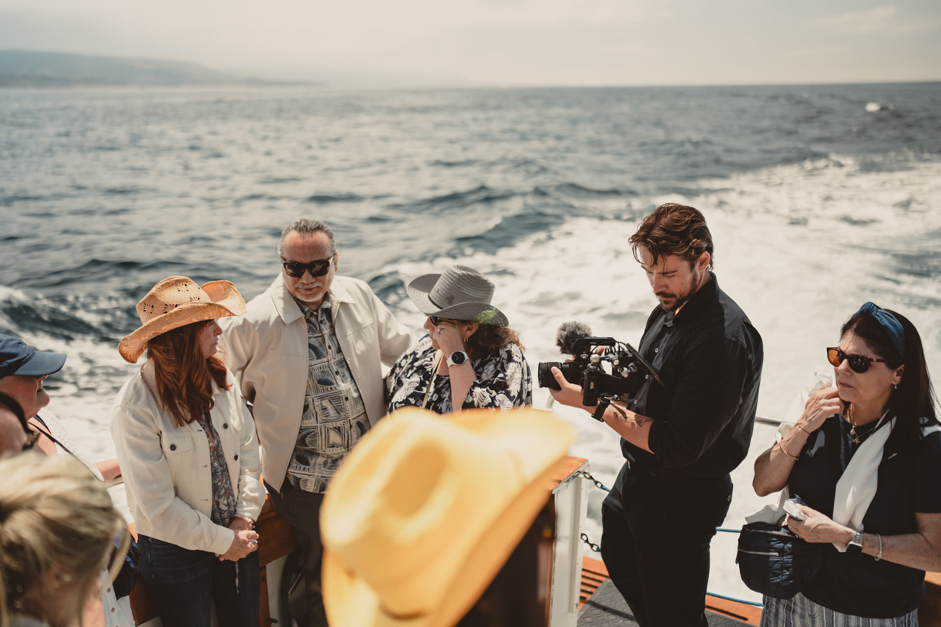 Jack filming a family gathering on a boat during the Doves funeral-at-sea